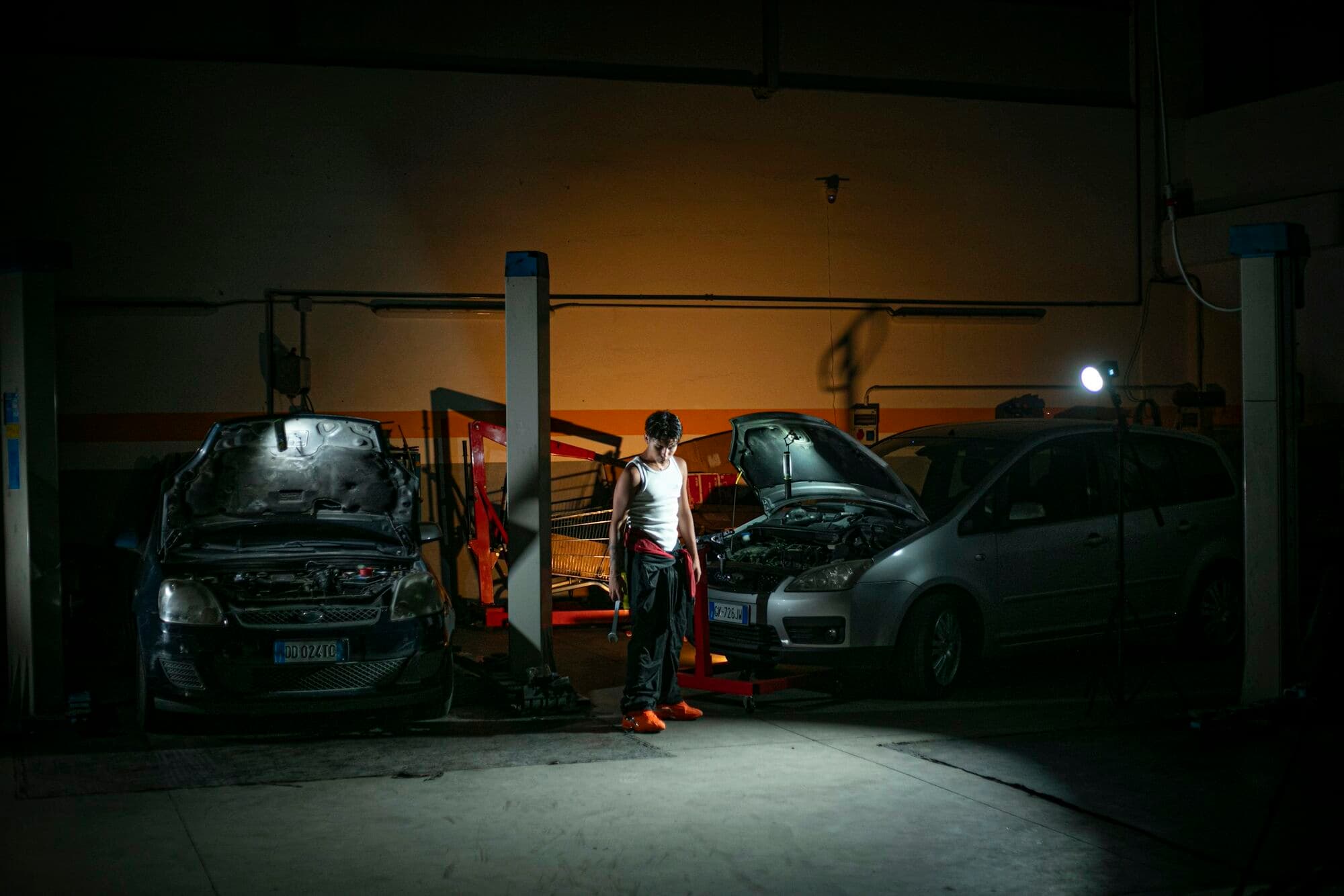 A Bartels Autocare technician at work between two vehicles on the workshop floor